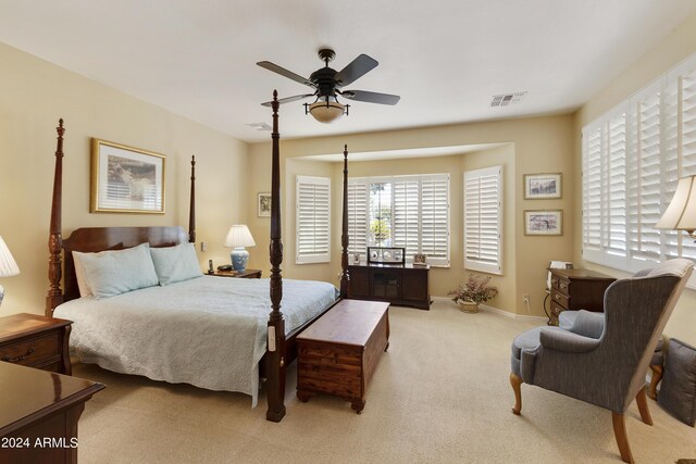 carpeted bedroom featuring multiple windows and ceiling fan