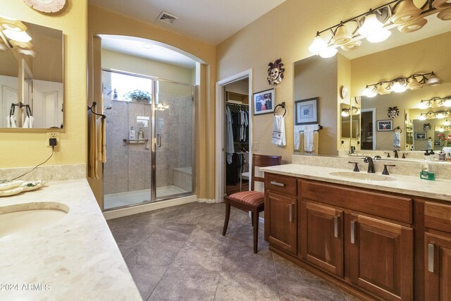 bathroom with vanity, a shower with door, and tile patterned floors