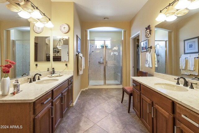 bathroom featuring tile patterned floors, a shower with shower door, and vanity