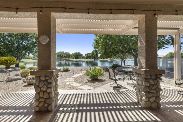 view of patio featuring a pergola and a water view