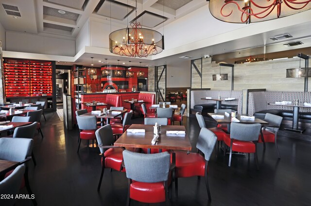 dining room with coffered ceiling, a towering ceiling, and a chandelier