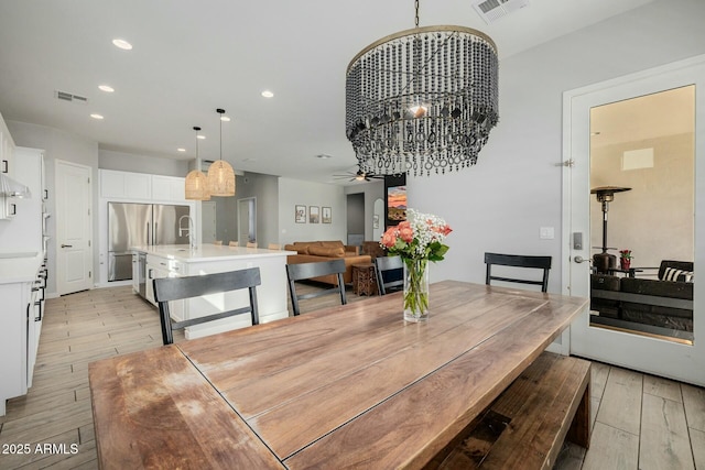 dining room featuring light wood finished floors, visible vents, and recessed lighting