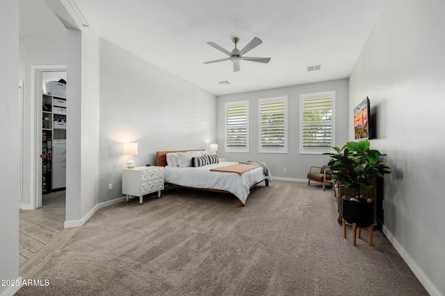 bedroom with visible vents, a spacious closet, a ceiling fan, carpet flooring, and baseboards