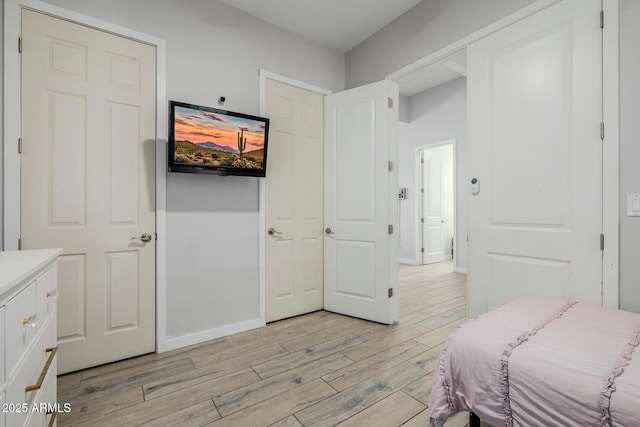 bedroom featuring light wood-type flooring and baseboards