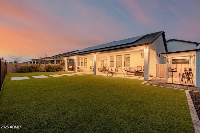 back of property featuring stucco siding, a patio, a fenced backyard, and a lawn