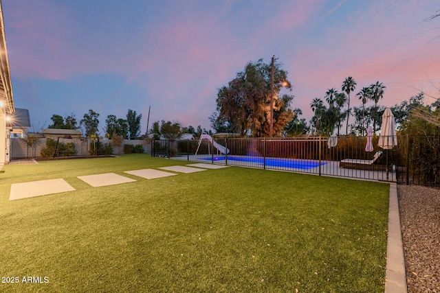 view of yard featuring a fenced in pool, a fenced backyard, and a playground