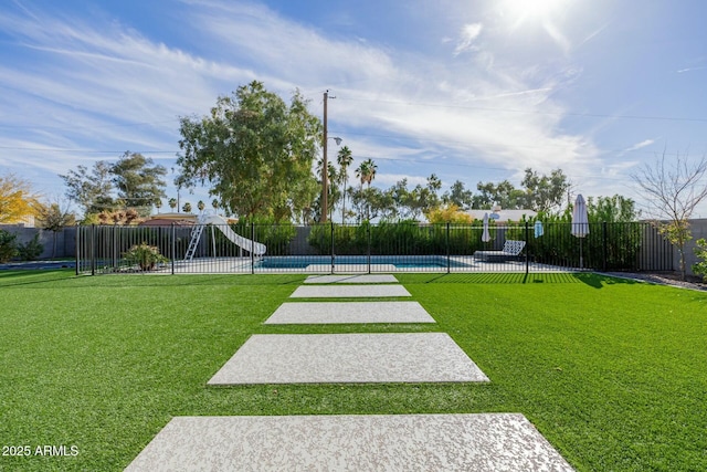 view of home's community with fence, a pool, and a lawn