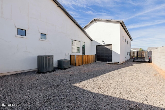 view of property exterior featuring fence, cooling unit, and stucco siding