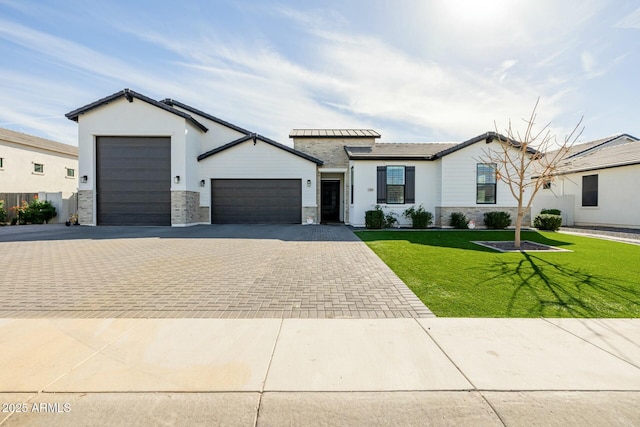 view of front facade with a garage, stone siding, a front lawn, and decorative driveway