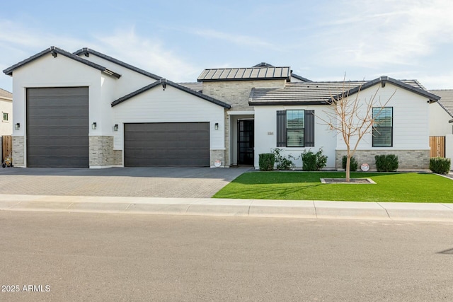 ranch-style home featuring an attached garage, stone siding, decorative driveway, and a front yard