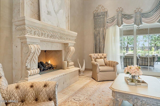 sitting room with a fireplace and a high ceiling