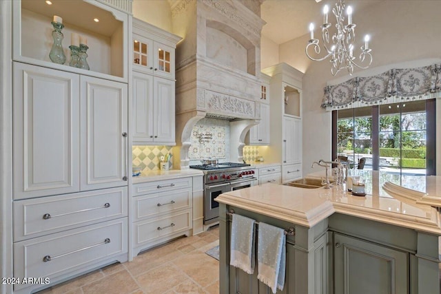 kitchen featuring sink, hanging light fixtures, tasteful backsplash, double oven range, and white cabinets