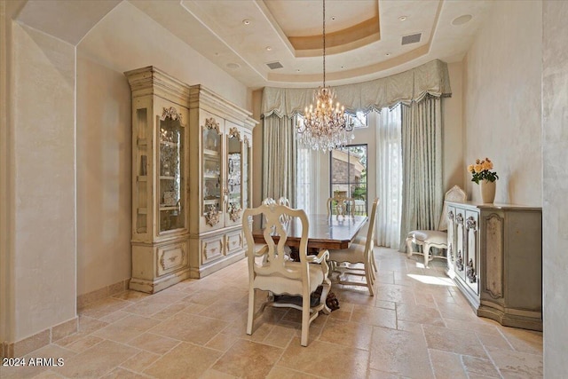 dining room with a tray ceiling and a notable chandelier