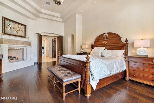 bedroom with dark hardwood / wood-style floors and a high ceiling