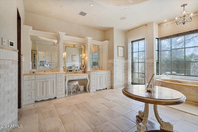 bathroom with vanity, a tub to relax in, and tile walls