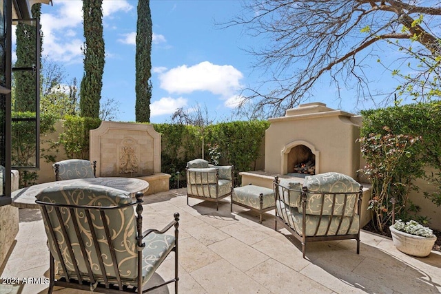 view of patio with an outdoor fireplace