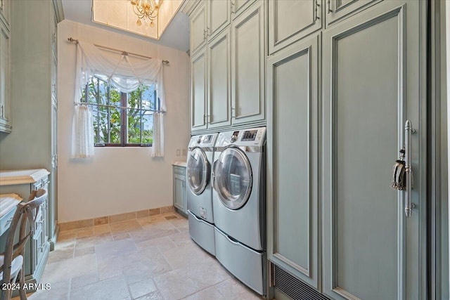 laundry room with washer and dryer and cabinets