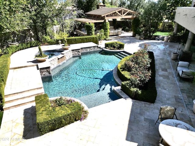 view of swimming pool featuring an in ground hot tub and a patio