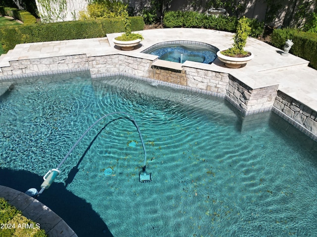 view of swimming pool with an in ground hot tub