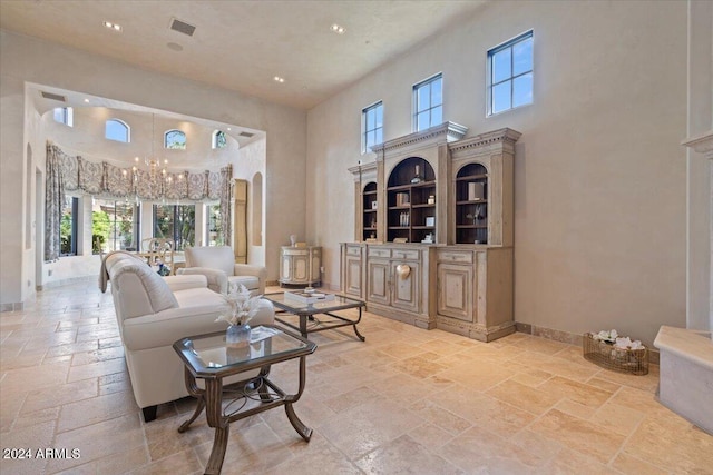 living room with a high ceiling and an inviting chandelier