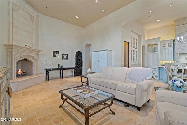 living room featuring a towering ceiling and a high end fireplace