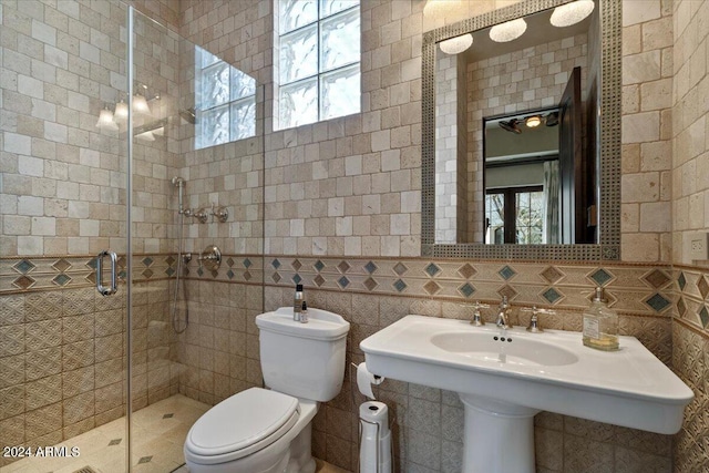 bathroom featuring an enclosed shower, toilet, and tile walls