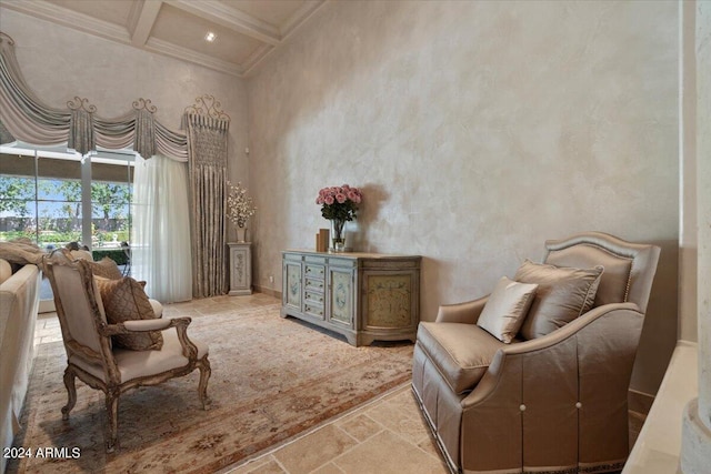 sitting room featuring beamed ceiling, ornamental molding, coffered ceiling, and a high ceiling