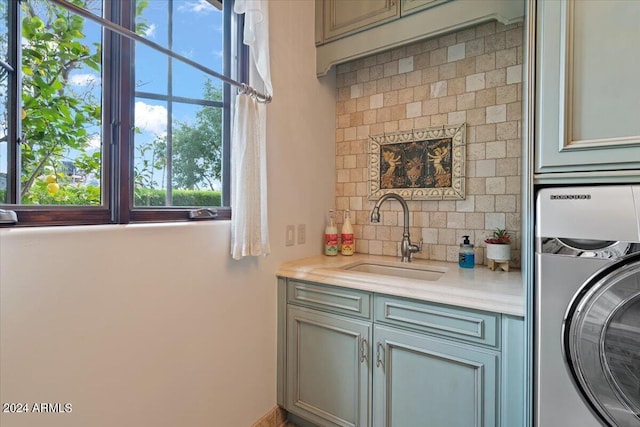 laundry area with cabinets, sink, and washer / clothes dryer