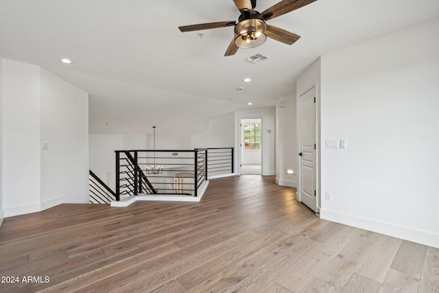 unfurnished room with ceiling fan, vaulted ceiling, and light hardwood / wood-style flooring