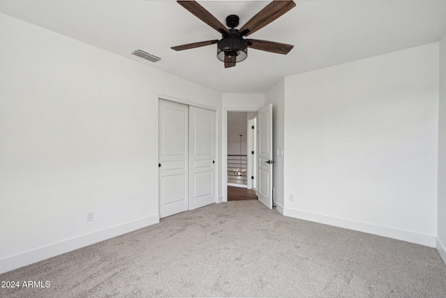 unfurnished bedroom featuring carpet, ceiling fan, and a closet