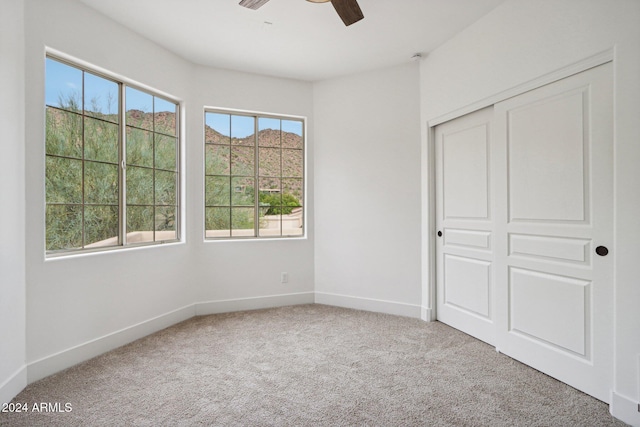 unfurnished bedroom with carpet flooring, a closet, and ceiling fan