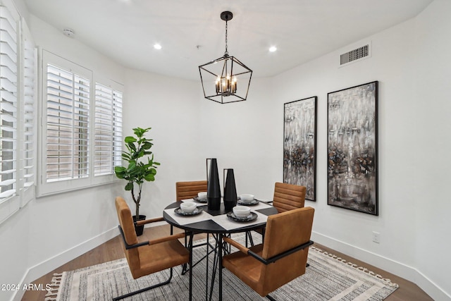 dining space featuring wood-type flooring and a chandelier