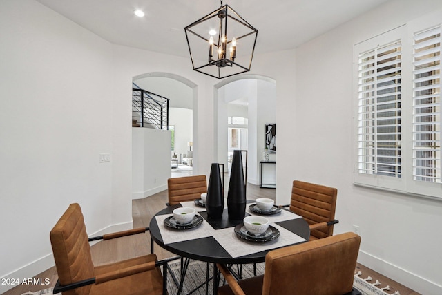 dining space featuring hardwood / wood-style flooring and a notable chandelier