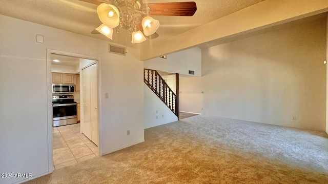 spare room with ceiling fan, light colored carpet, and a textured ceiling