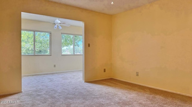 carpeted empty room featuring a textured ceiling and ceiling fan