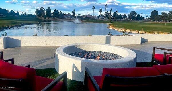 view of pool with a water view, a patio area, and an outdoor fire pit