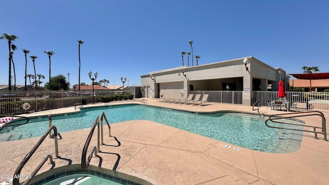 view of swimming pool with a hot tub and a patio area