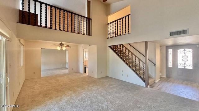 entryway with light carpet, a high ceiling, and ceiling fan