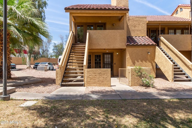 4901 S Calle Los Cerros Dr Unit 220, Tempe, AZ 85282 - view of front of home featuring stairway, a tile roof, stucco siding, and a chimney