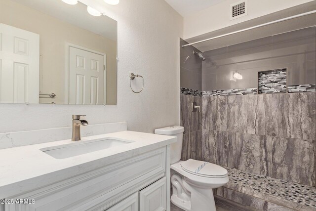4901 S Calle Los Cerros Dr Unit 220, Tempe, AZ 85282 - bathroom with toilet, vanity, a tile shower, and a textured wall