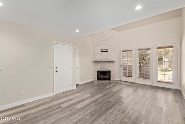 4901 S Calle Los Cerros Dr Unit 220, Tempe, AZ 85282 - unfurnished living room featuring wood finished floors, baseboards, a stone fireplace, recessed lighting, and a towering ceiling