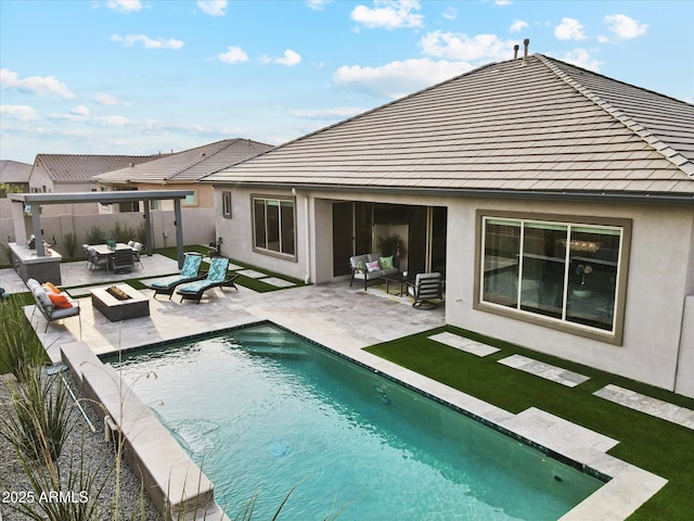 rear view of house with a fenced in pool, an outdoor living space with a fire pit, and a patio