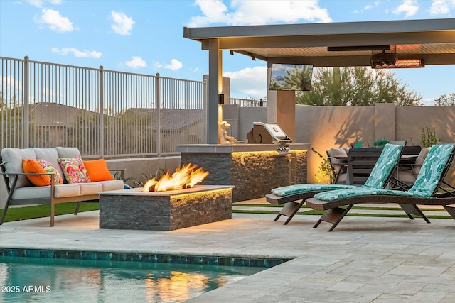 view of patio featuring exterior kitchen, grilling area, and a fire pit