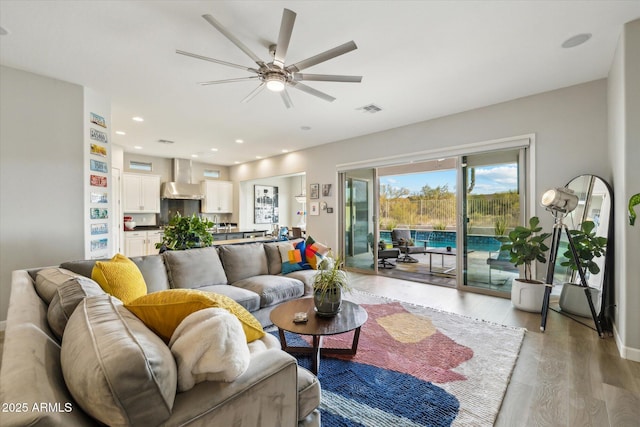 living room with ceiling fan and light wood-type flooring