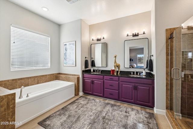 bathroom featuring vanity, shower with separate bathtub, and hardwood / wood-style floors