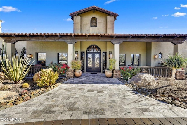 doorway to property with covered porch and french doors