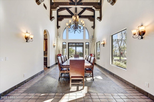 dining space with an inviting chandelier, high vaulted ceiling, and beamed ceiling