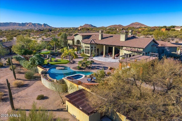 view of swimming pool with a mountain view and an in ground hot tub