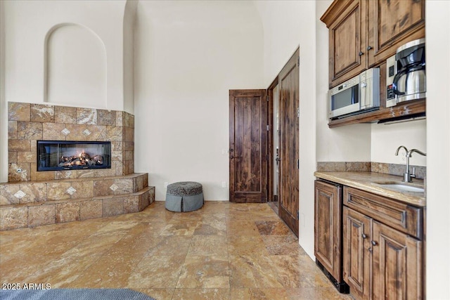 kitchen featuring a tiled fireplace and sink