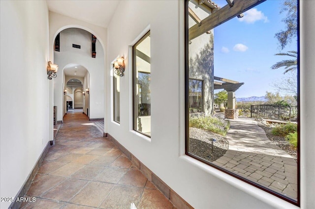 corridor featuring plenty of natural light and a mountain view